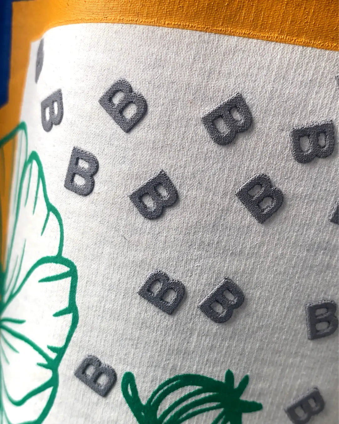 Blue fabric with black 'B' logos and green leaf design