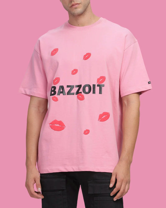 Person wearing a pink t-shirt with 'BAZZOIT' and red lip prints on a pink background