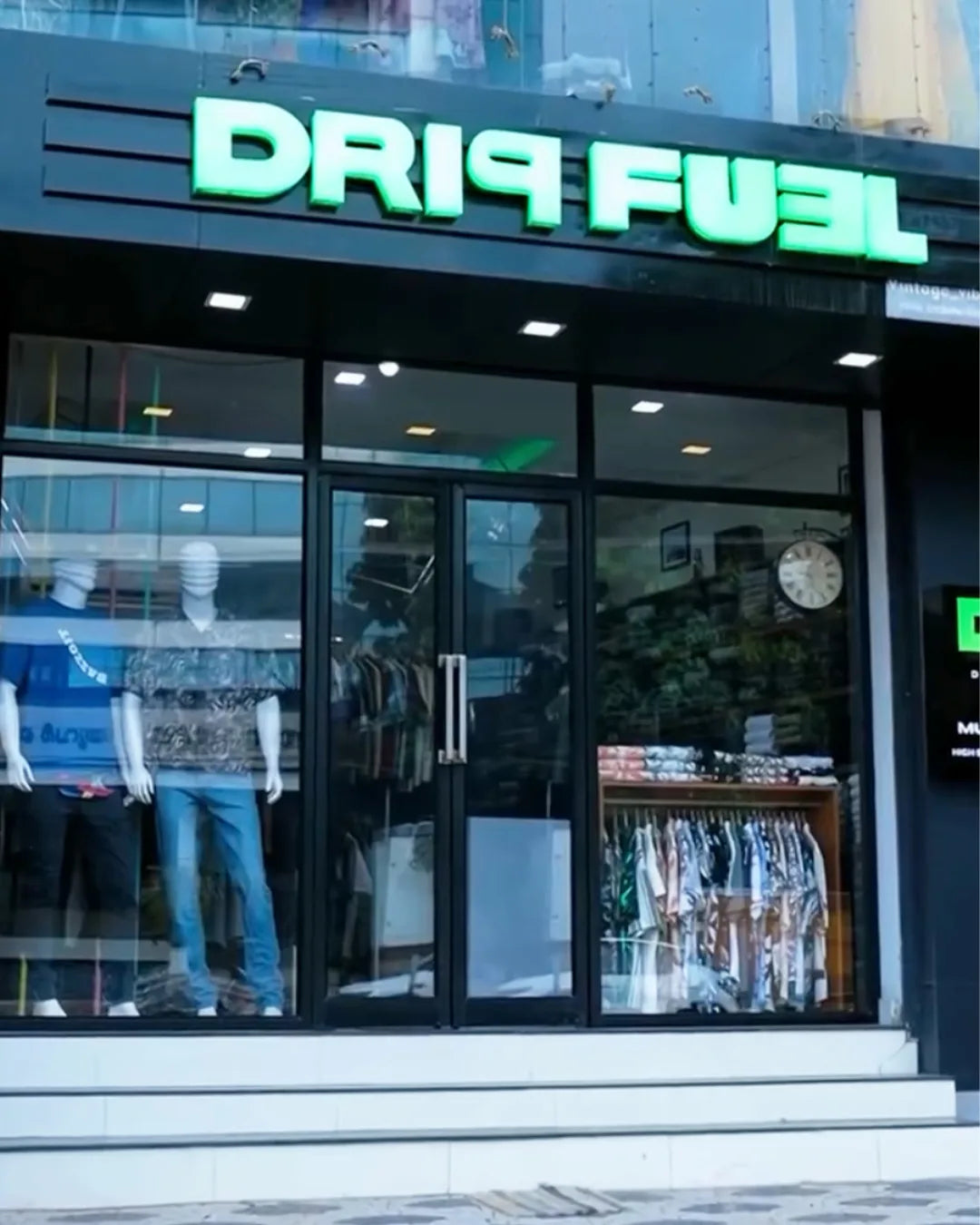 Storefront with 'Driq Fuel' sign and mannequins wearing branded clothing.